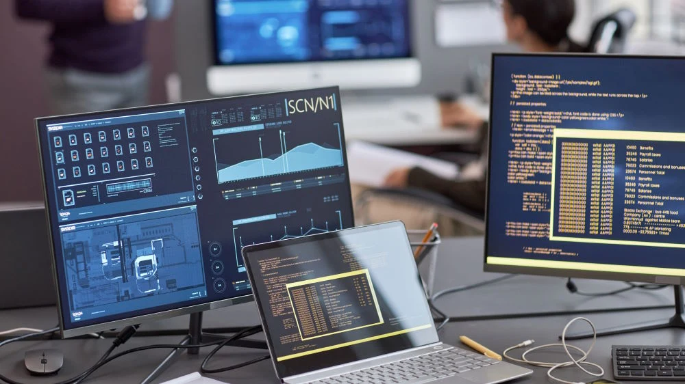 Developer workstation with code, data visualizations, and system interfaces